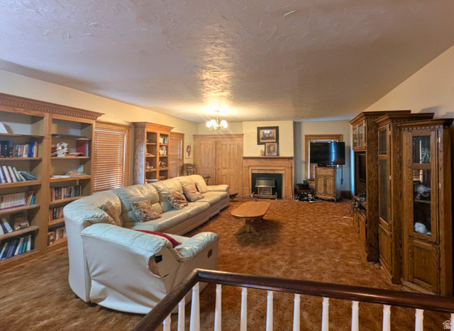 190 North 200 E Street Beaver, UT 84713 - Photo 32 of 40 Spacious living area featuring extensive built-in wooden shelving, a wood-surround fireplace, and textured ceiling
