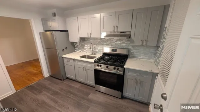 a kitchen with white cabinets and stainless steel appliances