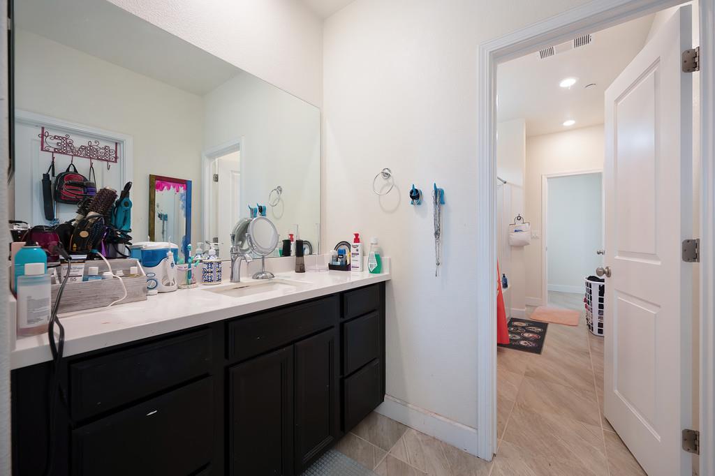 1004 Lavender Street Manteca, CA 95337 - Photo 18 of 35 a en suite bathroom with a double vanity sink a mirror and a shower