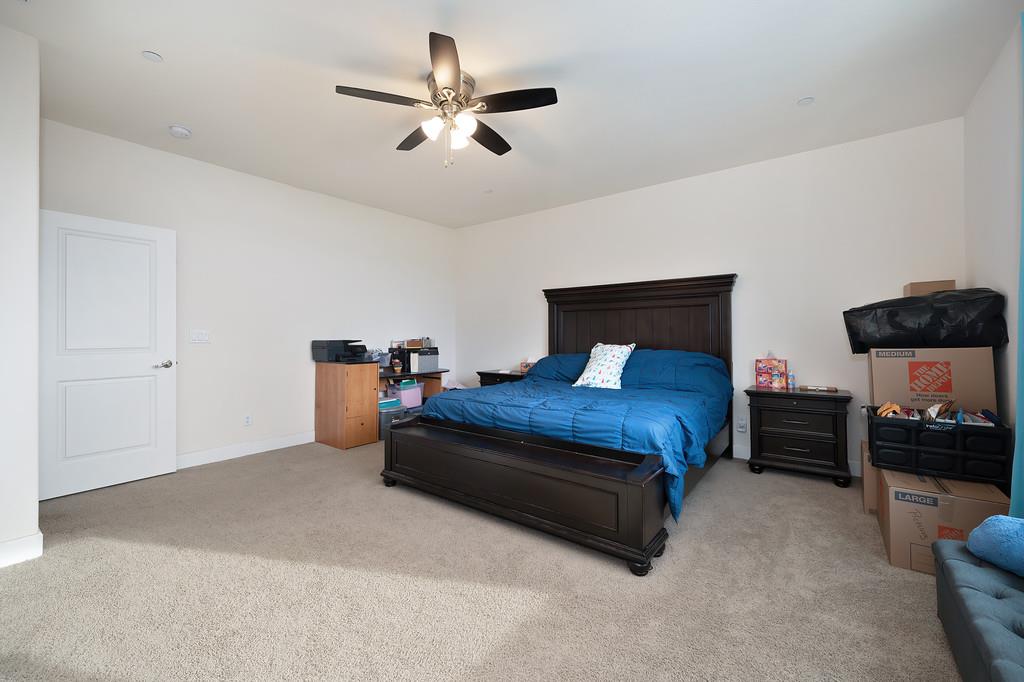 1004 Lavender Street Manteca, CA 95337 - Photo 26 of 35 a bedroom with a bed and a chandelier