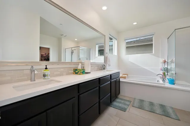 a bathroom with a tub a sink and mirror