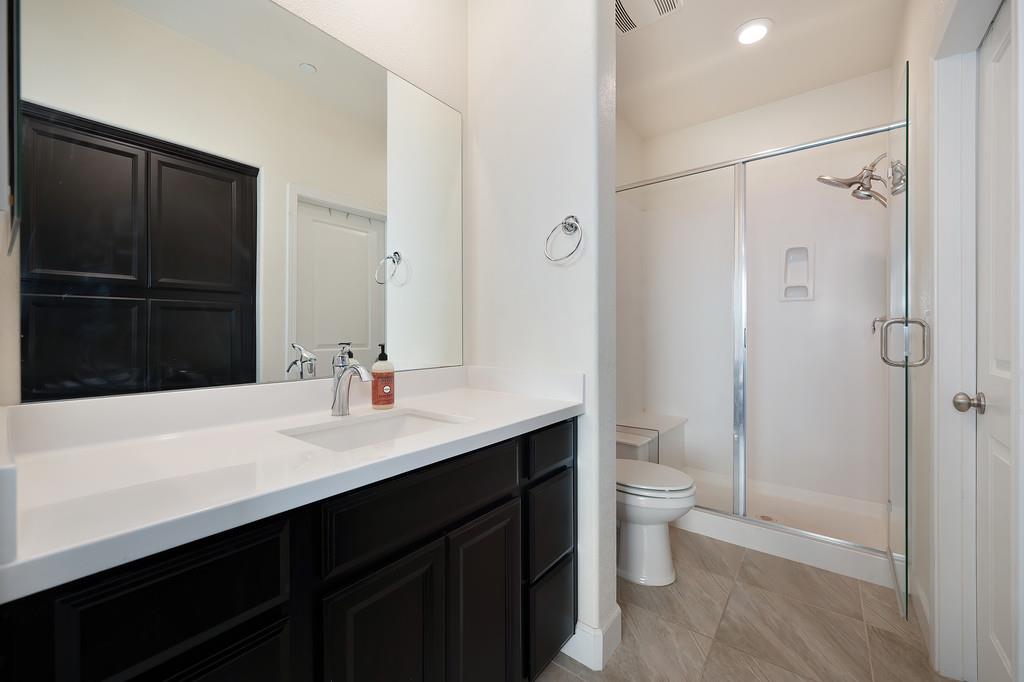 1004 Lavender Street Manteca, CA 95337 - Photo 31 of 35 a bathroom with a sink a toilet a shower and a mirror