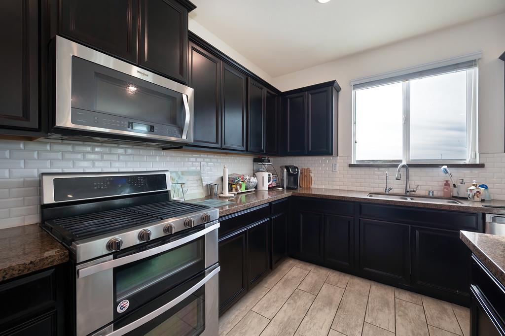 1004 Lavender Street Manteca, CA 95337 - Photo 7 of 35 a kitchen with a sink stove and microwave