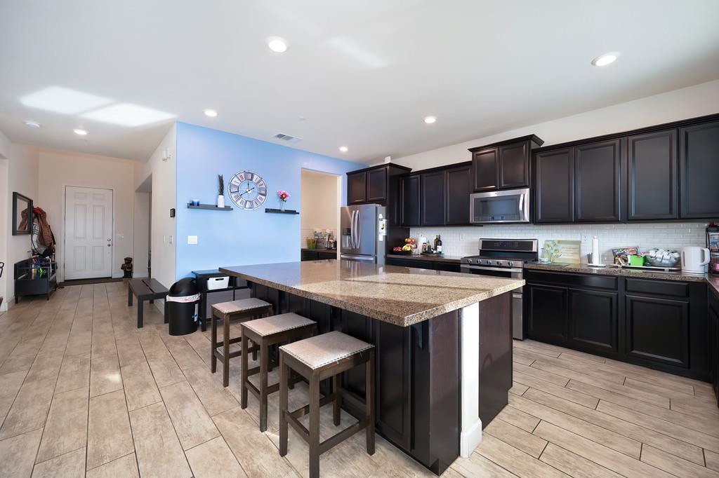 1004 Lavender Street Manteca, CA 95337 - Photo 8 of 35 a kitchen with a sink dishwasher a stove and a refrigerator with wooden floor