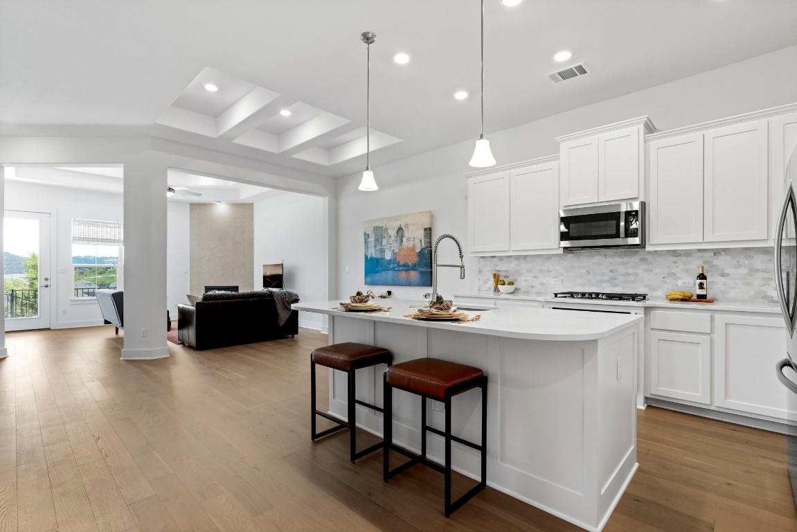 a kitchen with sink a microwave and cabinets