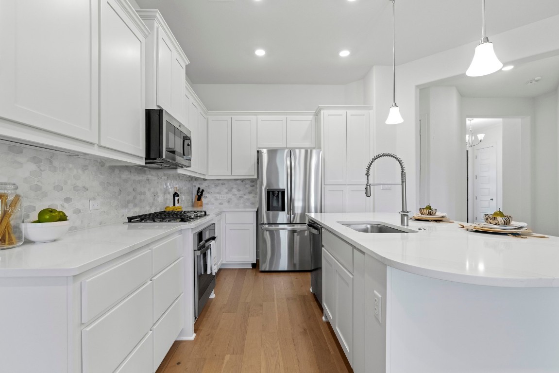 307 Cartwheel Bend Austin, TX 78738 - Photo 7 of 38 a kitchen with stainless steel appliances a sink stove and refrigerator
