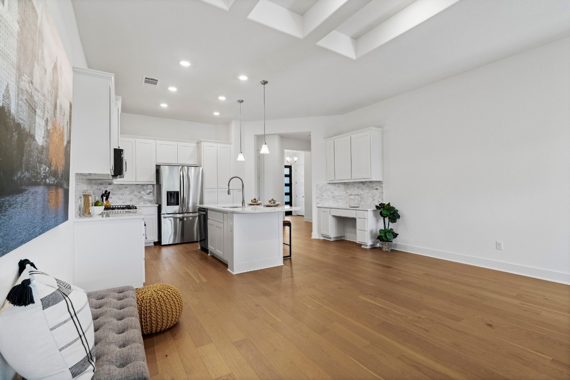 307 Cartwheel Bend Austin, TX 78738 - Photo 10 of 38 a large white kitchen with lots of counter space wooden floor and appliances