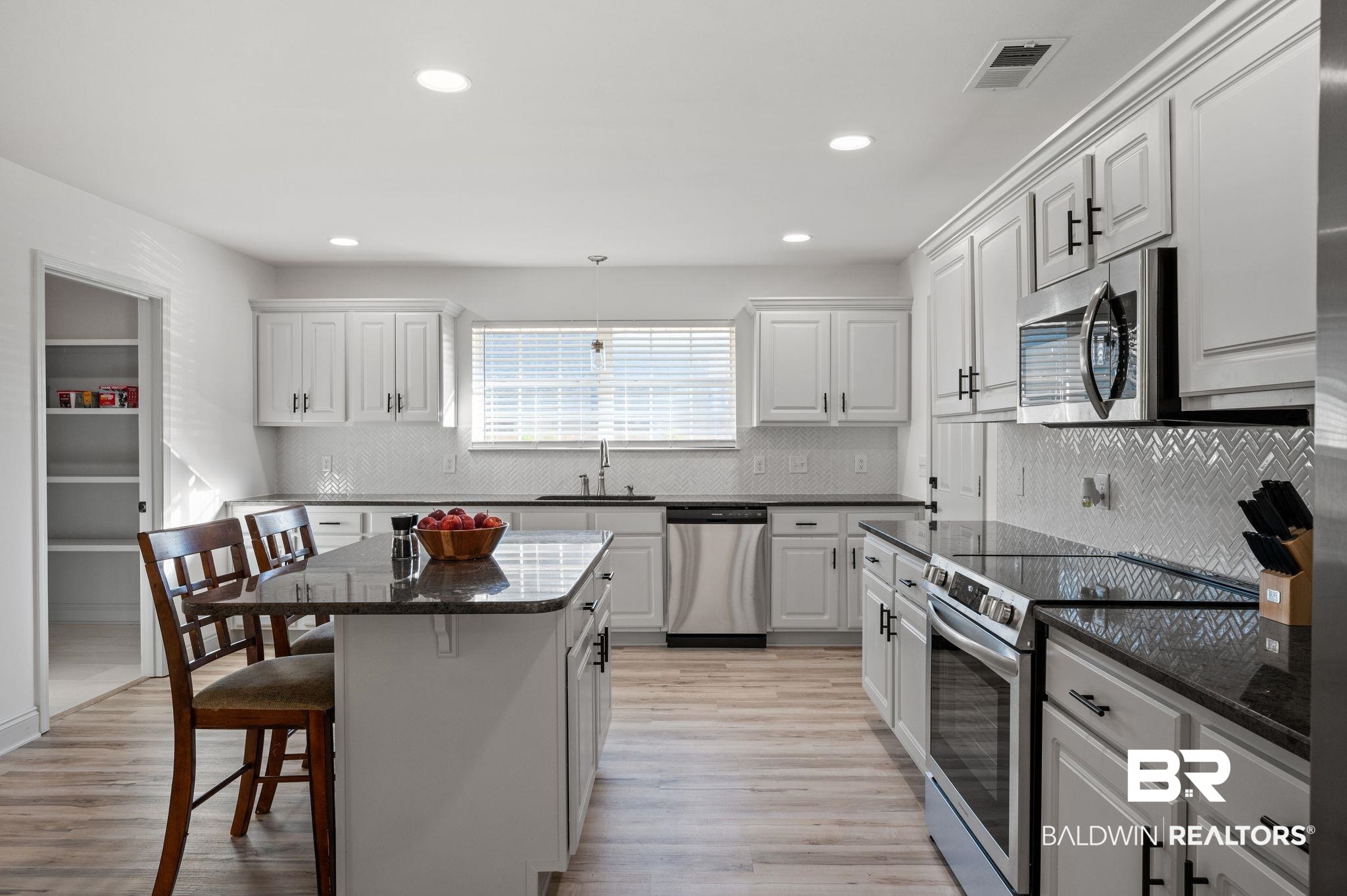 136 Destrehan Road Fairhope, AL 36532 - Photo 21 of 44 Kitchen with stainless steel appliances, light hardwood / wood-style floors, a breakfast bar area, and a center island