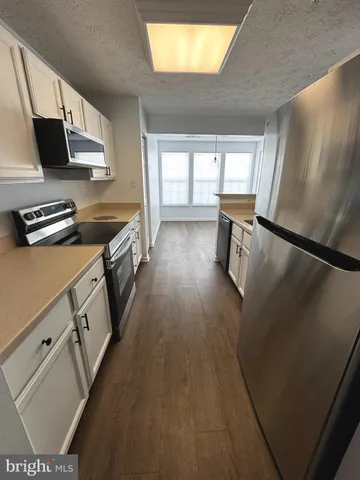 a kitchen with granite countertop a stove and a refrigerator