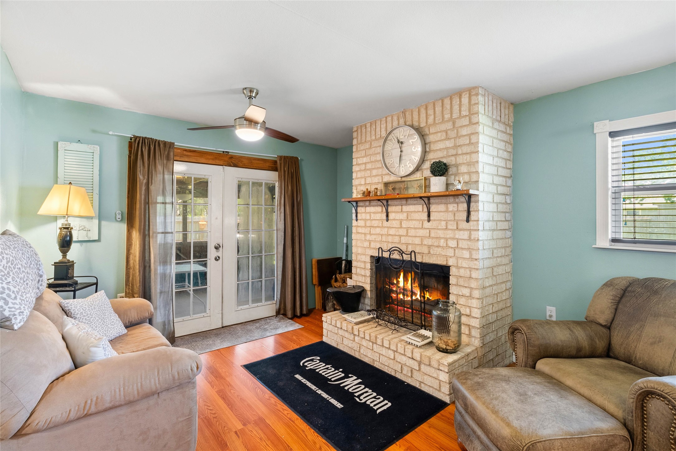 168 Sunset Ingleside, TX 78362 - Photo 8 of 26 Cozy secondary seating or den area featuring a classic brick fireplace as a focal point.