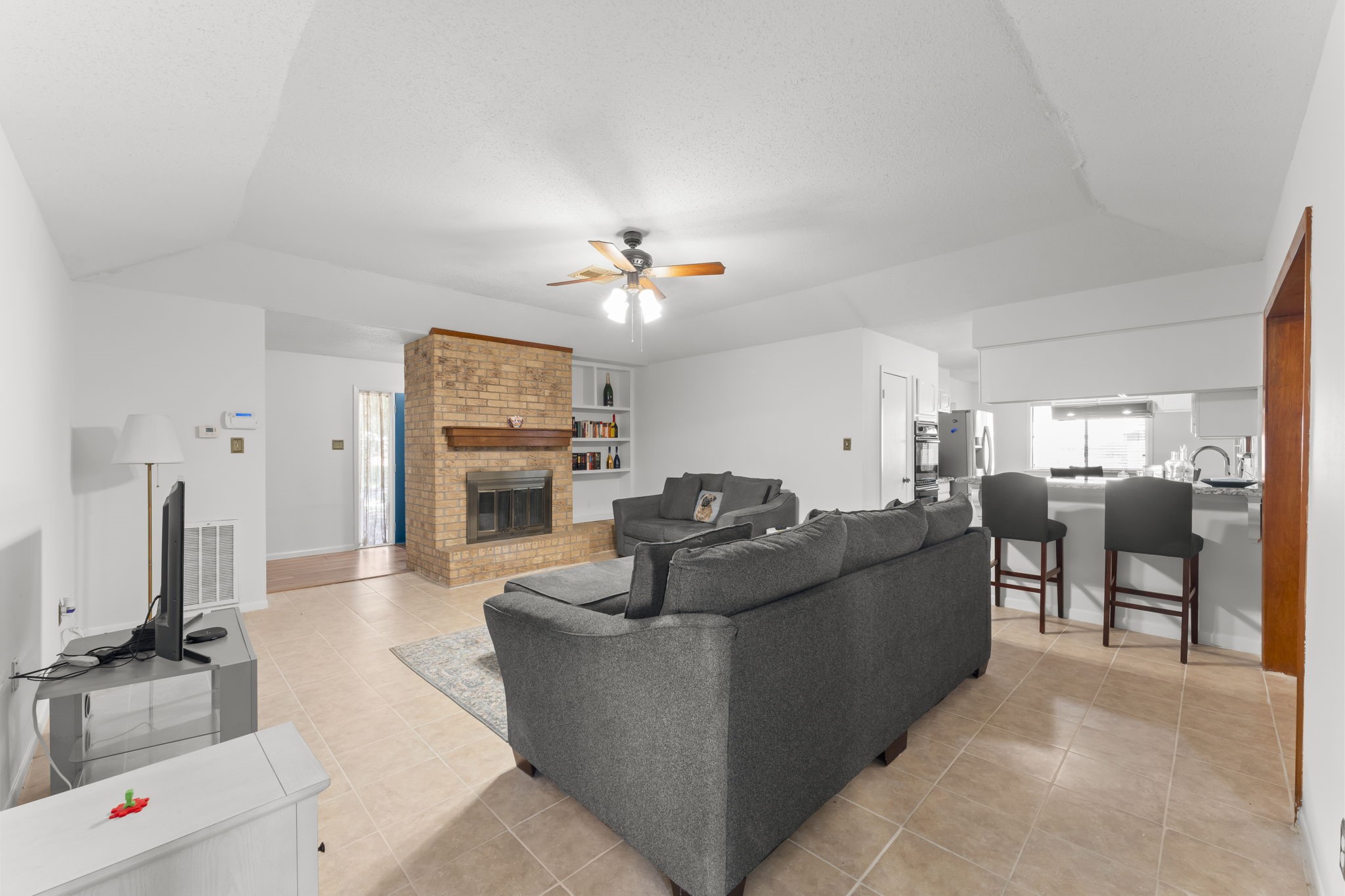 6103 Sunnygate Drive Spring, TX 77373 - Photo 4 of 25 a living room with furniture a fireplace and a flat screen tv