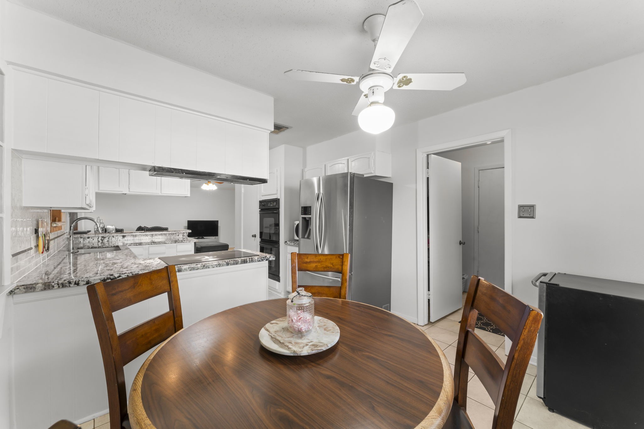 6103 Sunnygate Drive Spring, TX 77373 - Photo 10 of 25 a kitchen with stainless steel appliances kitchen island granite countertop a table and chairs