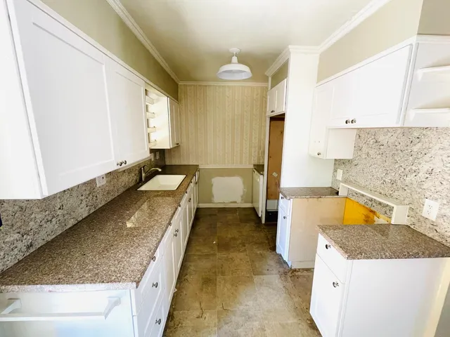 a bathroom with a granite countertop tub and a sink