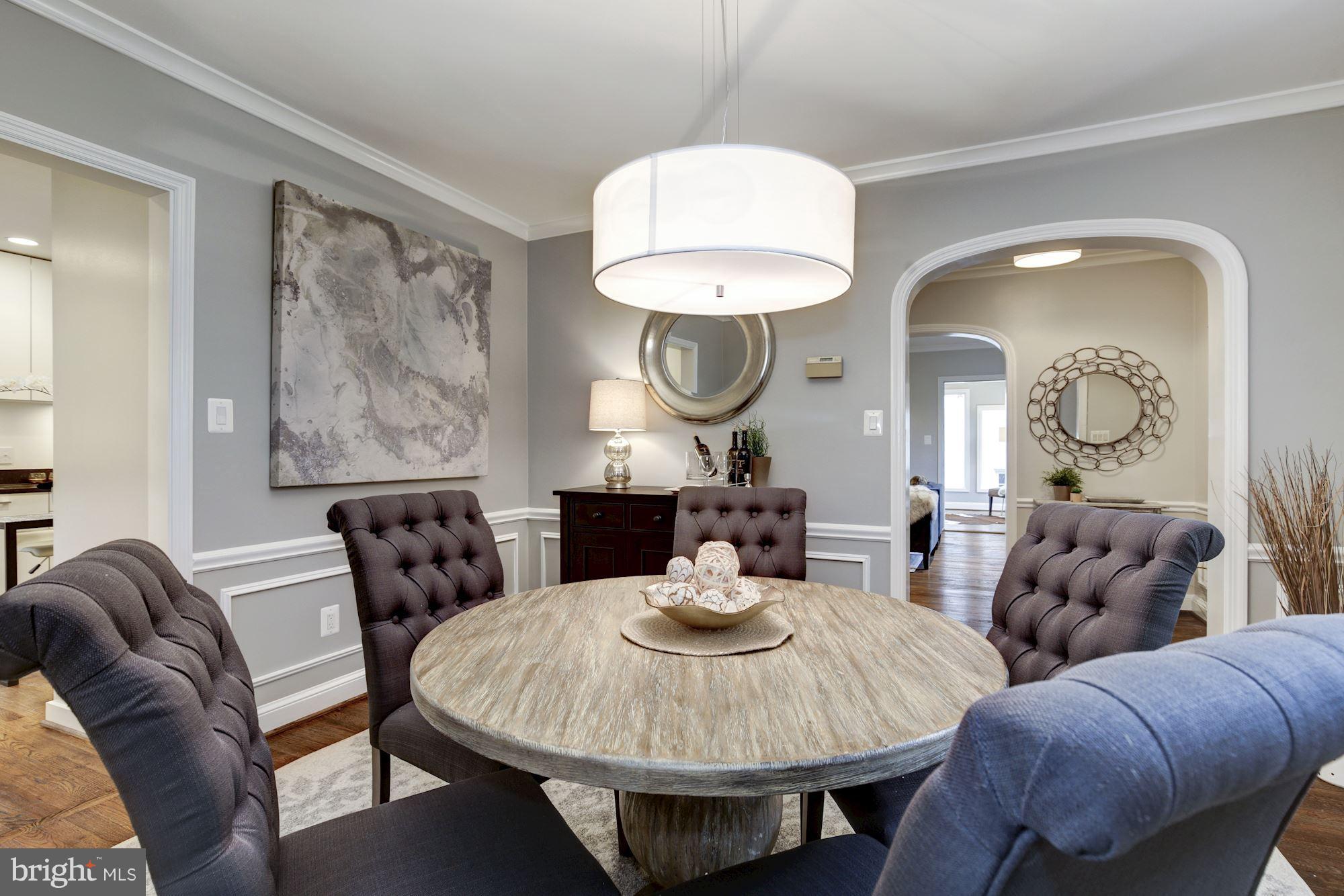 4814 Sedgwick Street Northwest Washington, DC 20016 - Photo 7 of 30 a living room with couches a mirror and a dining table with wooden floor