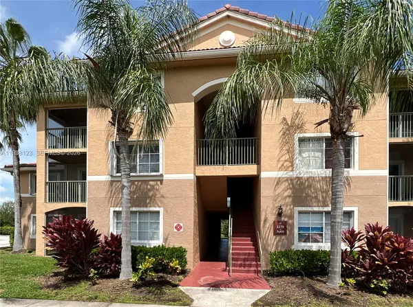 a front view of a multi story residential apartment building with a yard