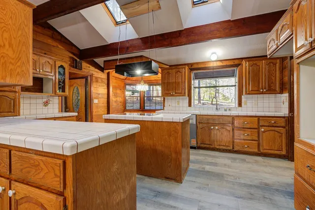 a kitchen with stainless steel appliances granite countertop a sink and wooden cabinets