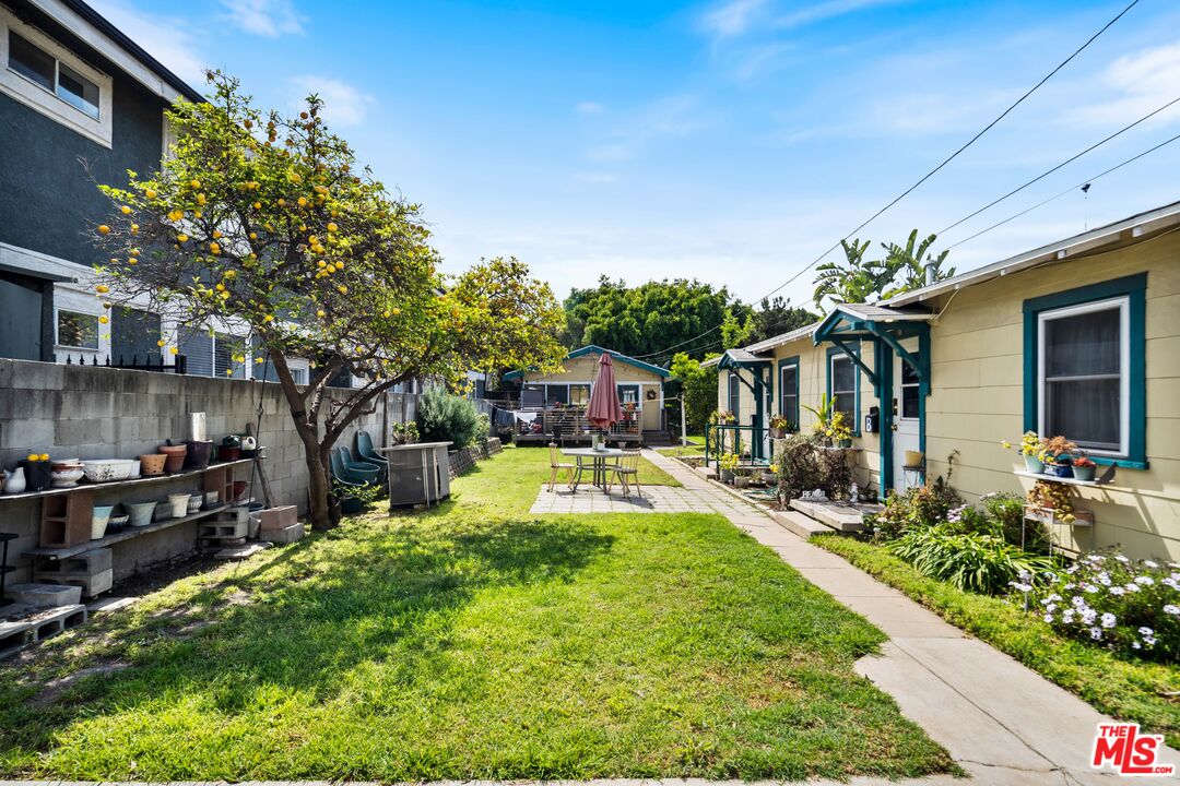 1747 9th Street Santa Monica, CA 90404 - Photo 22 of 24 a view of a backyard with table and chairs potted plants and large tree
