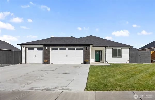 a front view of a house with a yard and garage