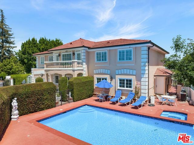 a view of a house with swimming pool and sitting area