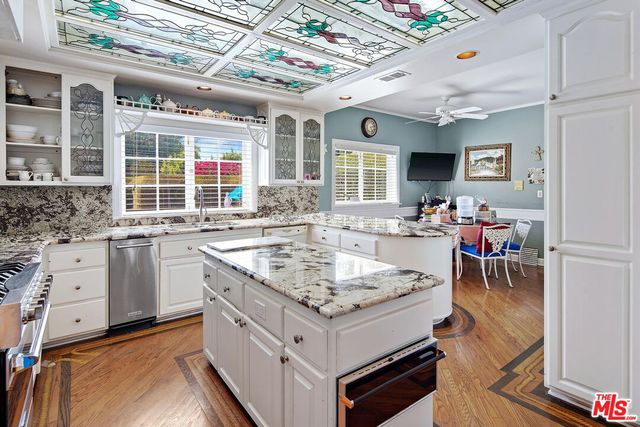 a kitchen with stainless steel appliances granite countertop a stove and cabinets