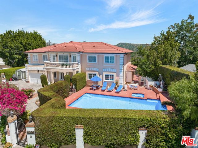 a view of swimming pool with a table and chairs under an umbrella