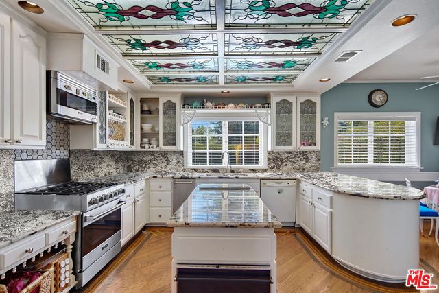 a large kitchen with granite countertop a stove and a sink