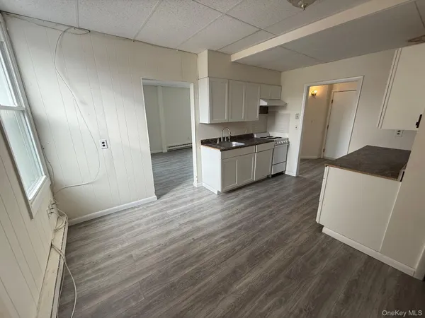 a large white kitchen with sink and refrigerator