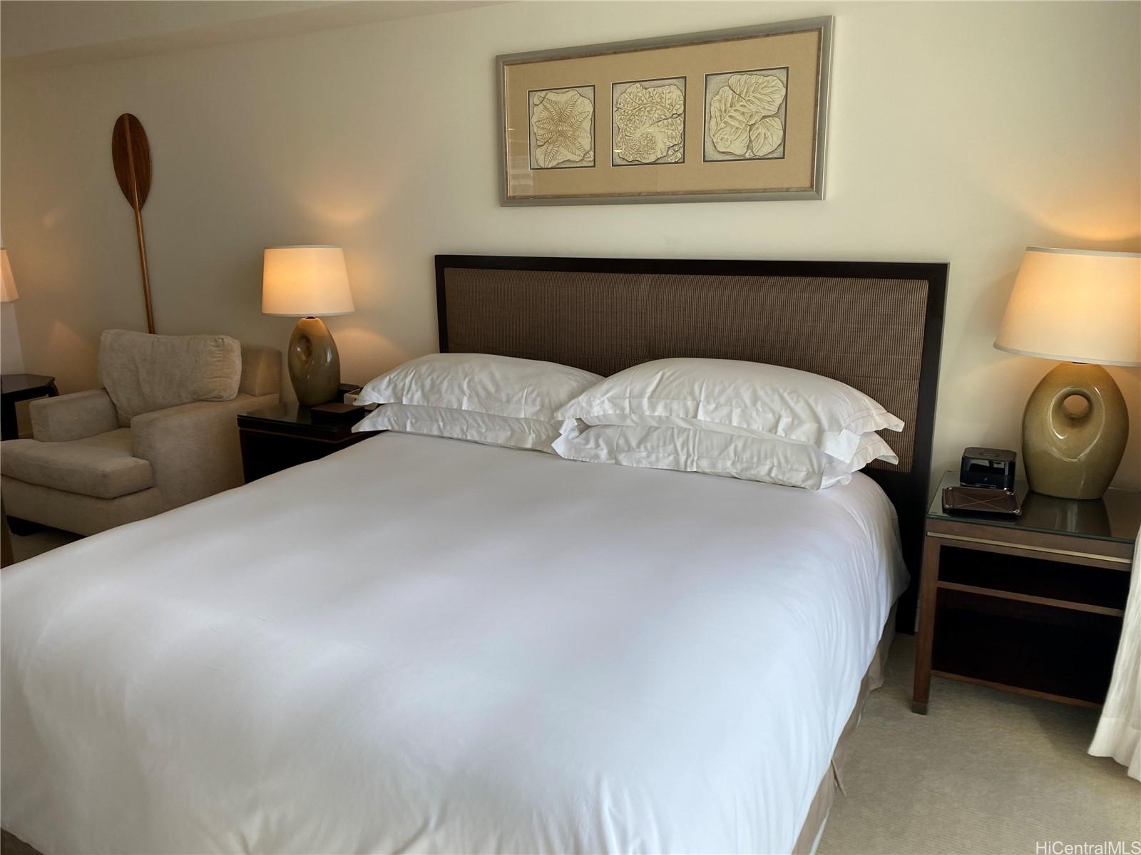 223 Saratoga Road, Unit 2316 Honolulu, HI 96815 - Photo 1 of 20 a bedroom with a bed and a lamp