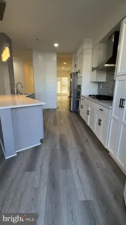 a large kitchen with stainless steel appliances wooden floors and wooden cabinets
