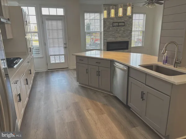a kitchen with granite countertop a sink stove and cabinets
