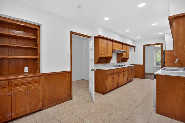 a large kitchen with stainless steel appliances a large counter top a stove and a refrigerator