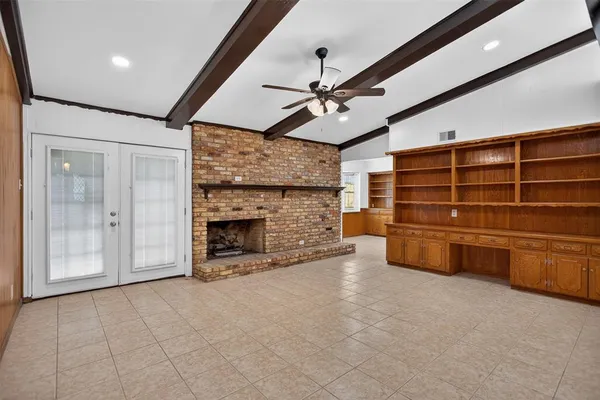 a view of an empty room with a fireplace and a window