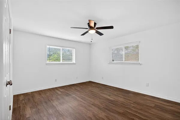 a view of a room with wooden floor and ceiling fan