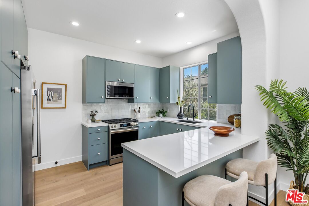 14234 Dickens Street, Unit 2 Sherman Oaks, CA 91423 - Photo 7 of 29 a kitchen with a sink a stove and chairs
