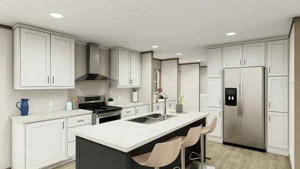 a kitchen with a refrigerator a stove a sink and white cabinets