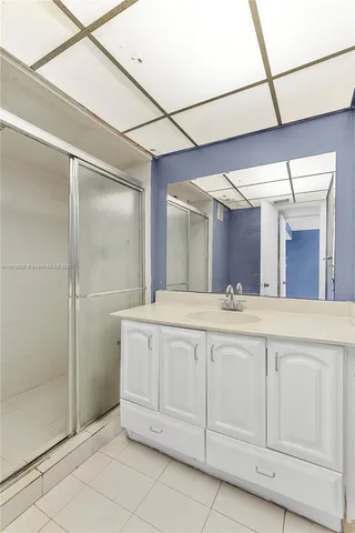 a spacious bathroom with a granite countertop sink mirror and shower