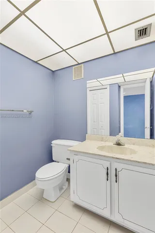 a bathroom with a granite countertop toilet and a sink