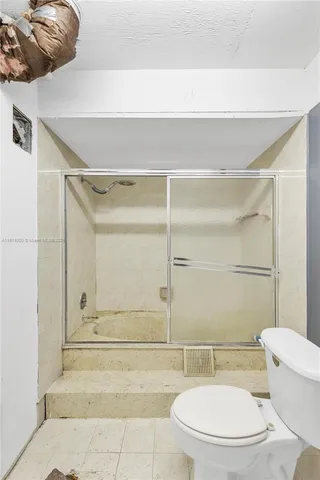 a bathroom with a toilet and a shower