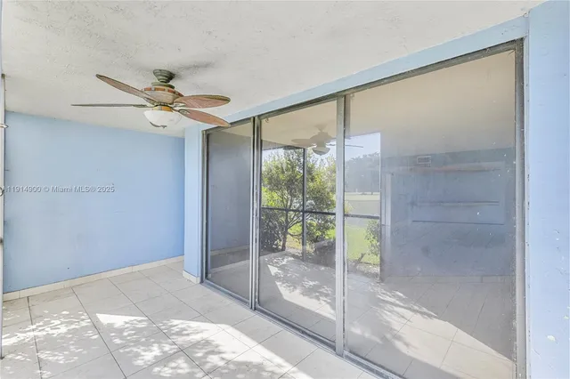 a view of a big room with a ceiling fan and window