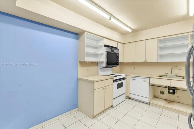 a kitchen with a stove sink and cabinets