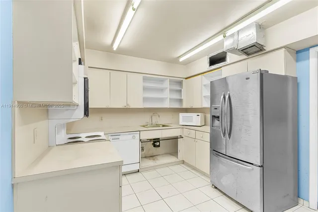 a kitchen with stainless steel appliances a refrigerator sink and cabinets