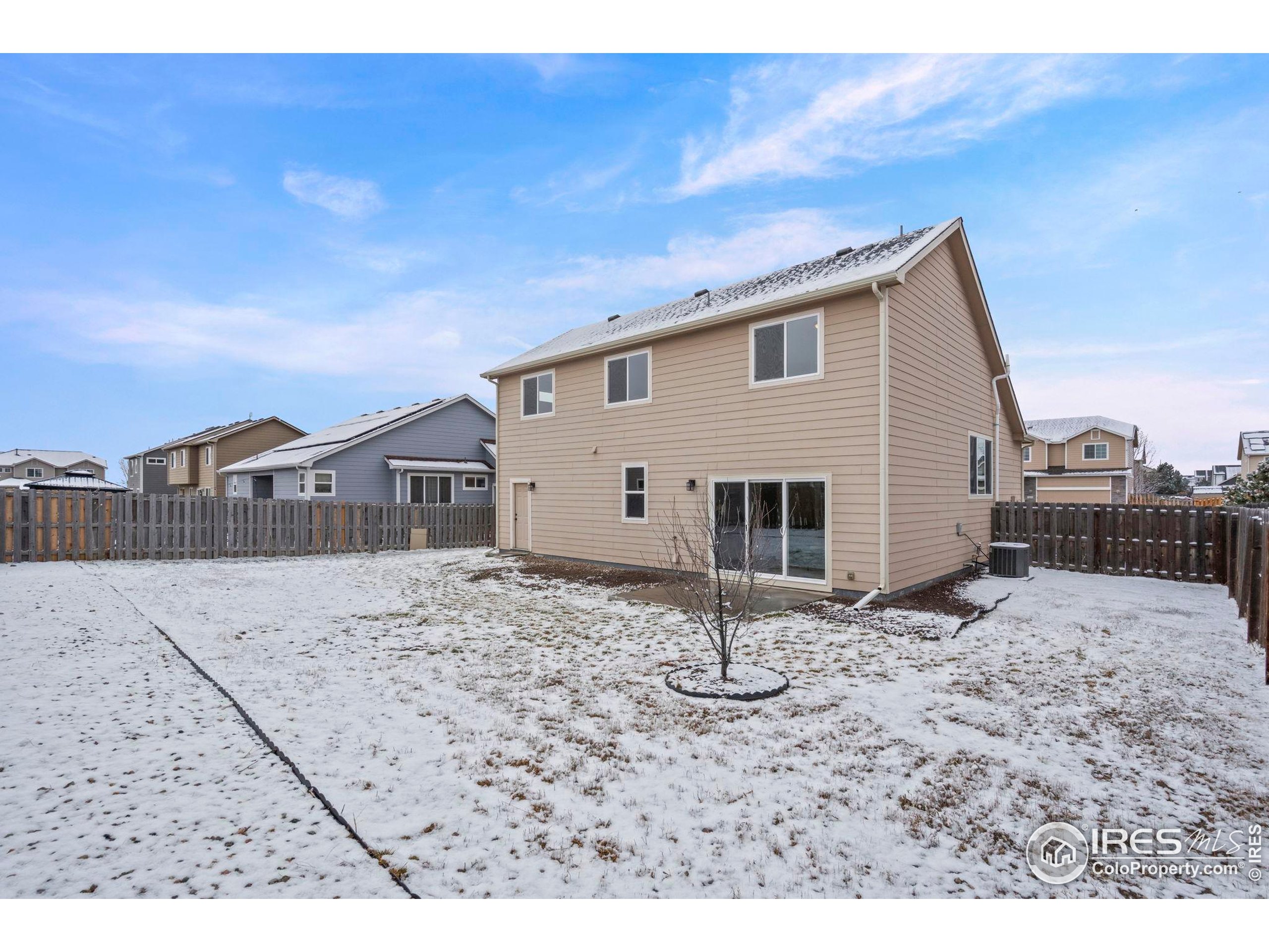 7324 Atlantis Street Wellington, CO 80549 - Photo 27 of 31 a view of a grey house with a yard