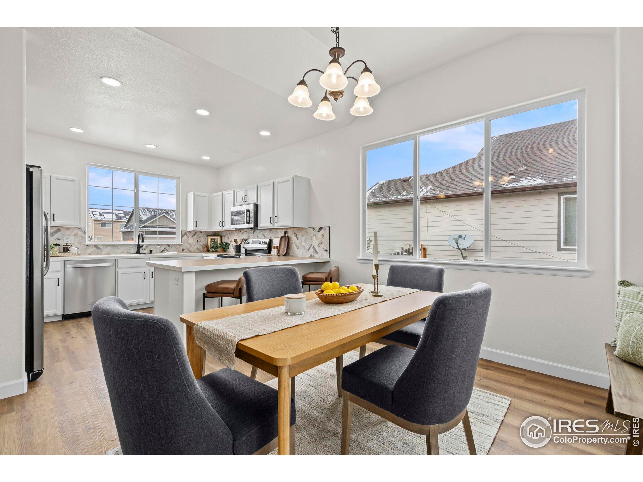 7324 Atlantis Street Wellington, CO 80549 - Photo 6 of 31 a view of a dining room with furniture and a chandelier
