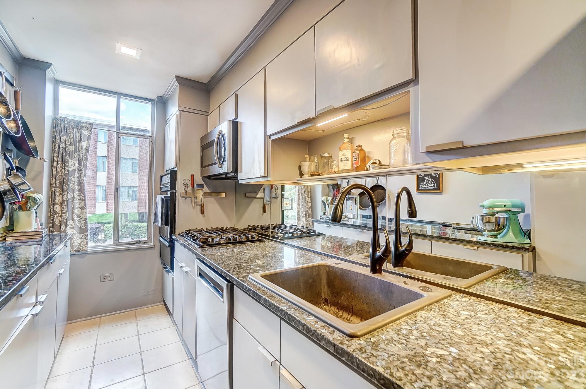 1300 Queens Road, Unit 208 Charlotte, NC 28207 - Photo 11 of 34 a kitchen with stainless steel appliances granite countertop a sink stove and cabinets