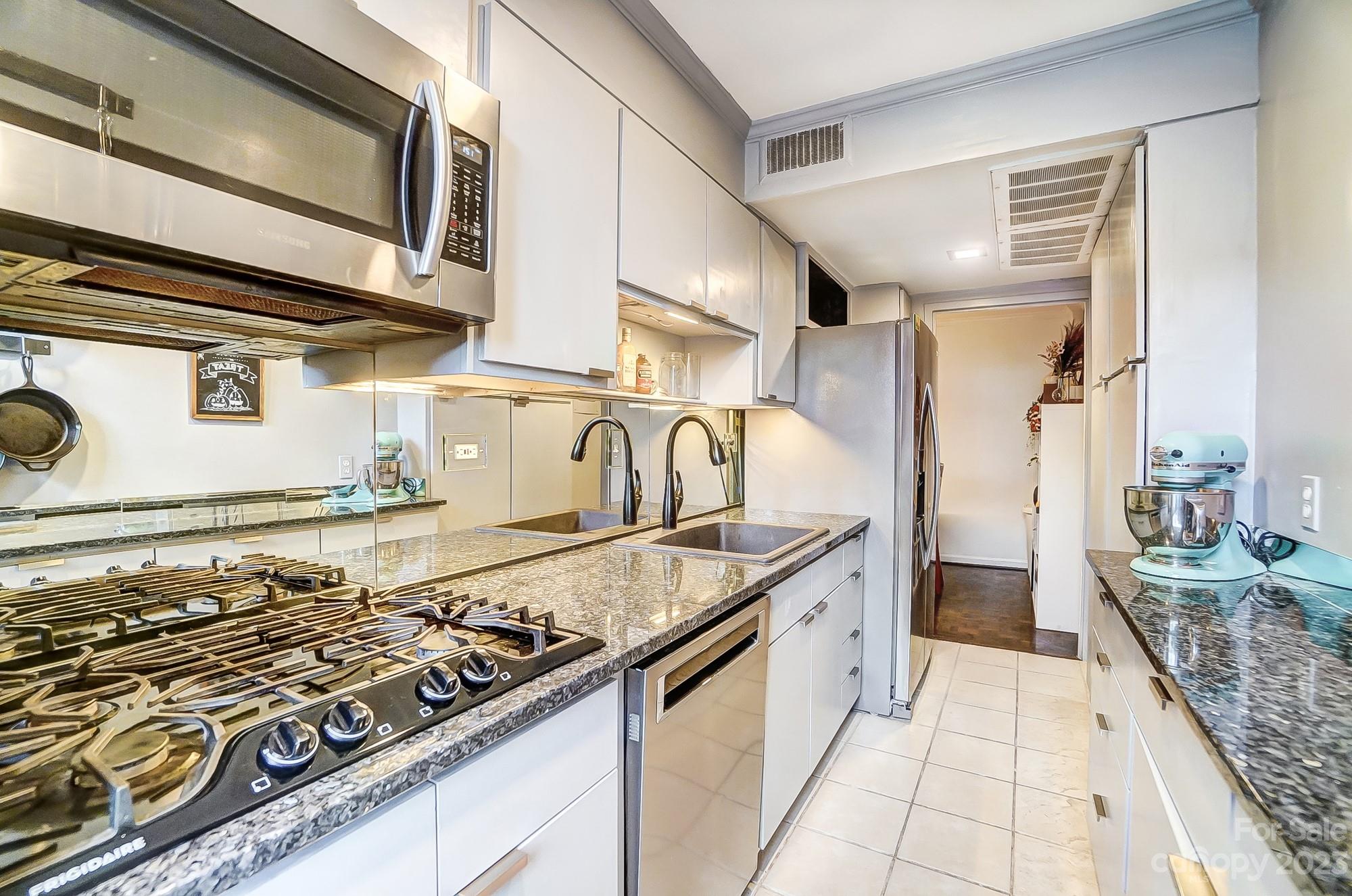 1300 Queens Road, Unit 208 Charlotte, NC 28207 - Photo 14 of 34 a kitchen with stainless steel appliances granite countertop a stove and a sink