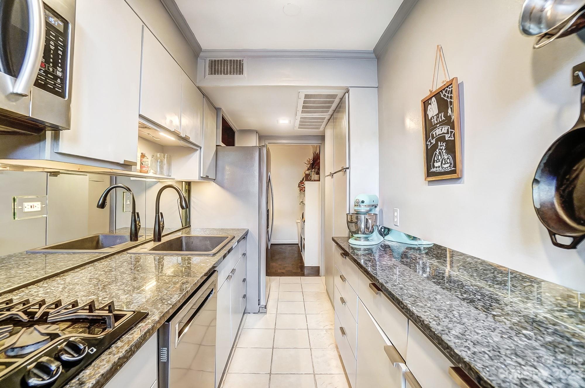 1300 Queens Road, Unit 208 Charlotte, NC 28207 - Photo 15 of 34 a kitchen with granite countertop a stove and a sink