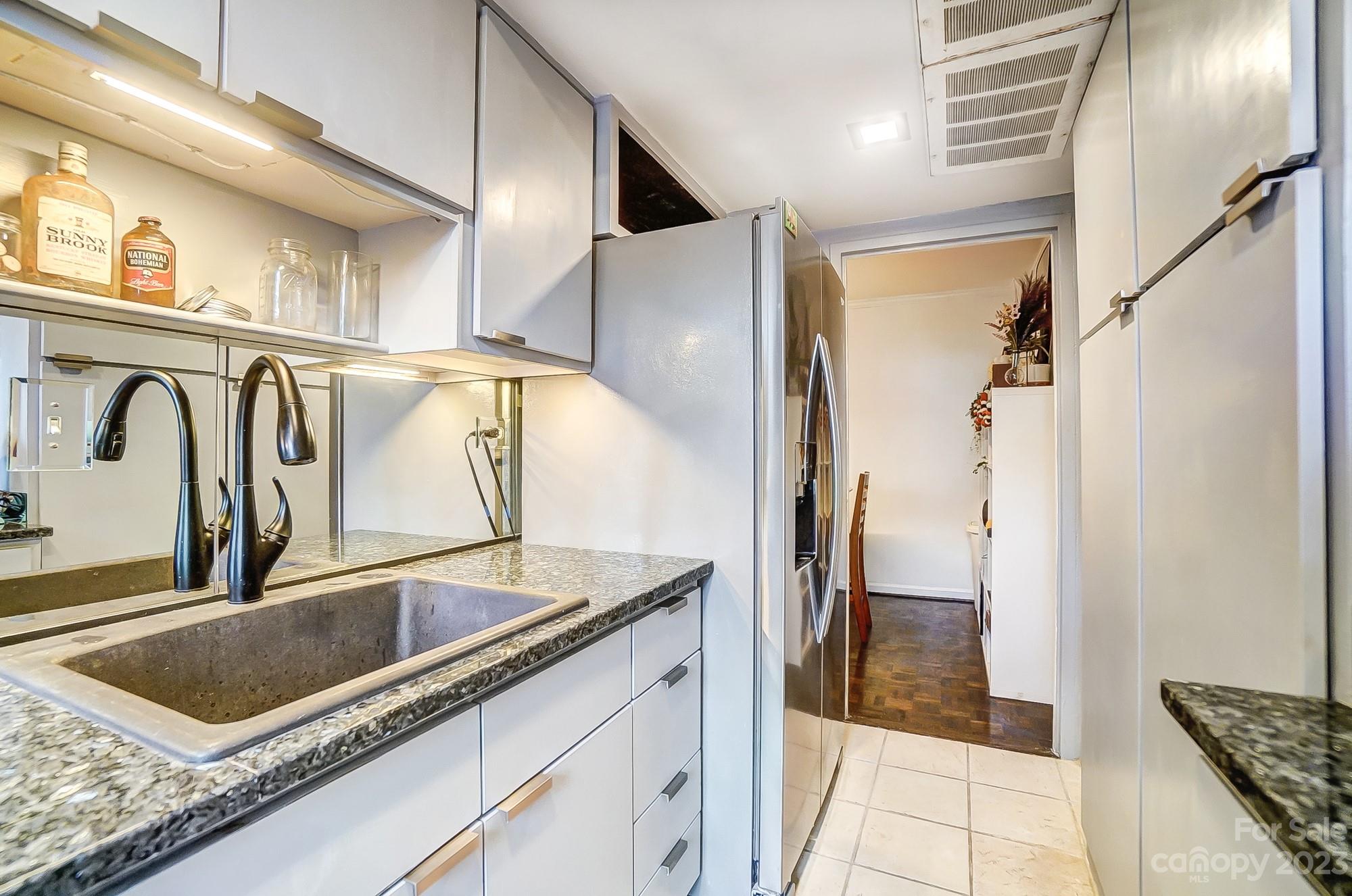1300 Queens Road, Unit 208 Charlotte, NC 28207 - Photo 16 of 34 a kitchen with stainless steel appliances granite countertop a sink and a refrigerator