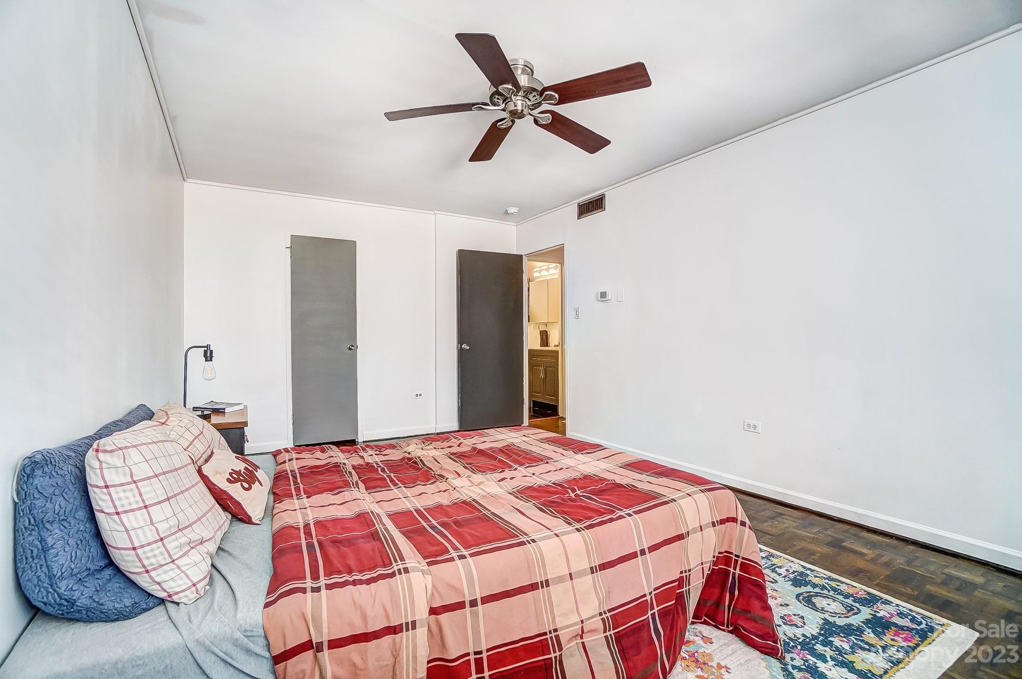 1300 Queens Road, Unit 208 Charlotte, NC 28207 - Photo 21 of 34 a bedroom with a bed and a chandelier