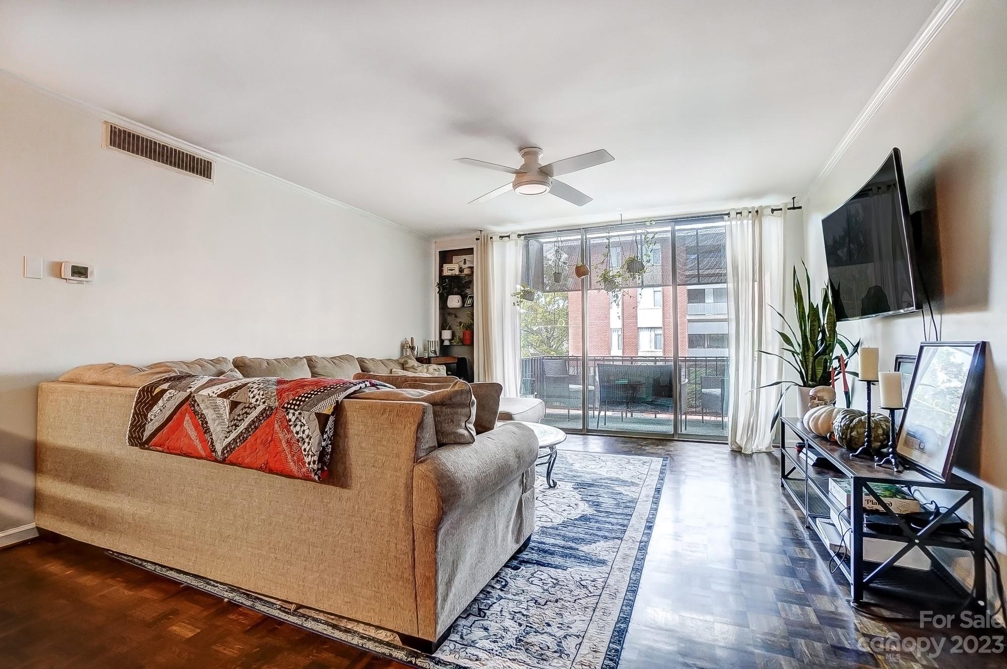 1300 Queens Road, Unit 208 Charlotte, NC 28207 - Photo 4 of 34 a living room with furniture a flat screen tv and a large window