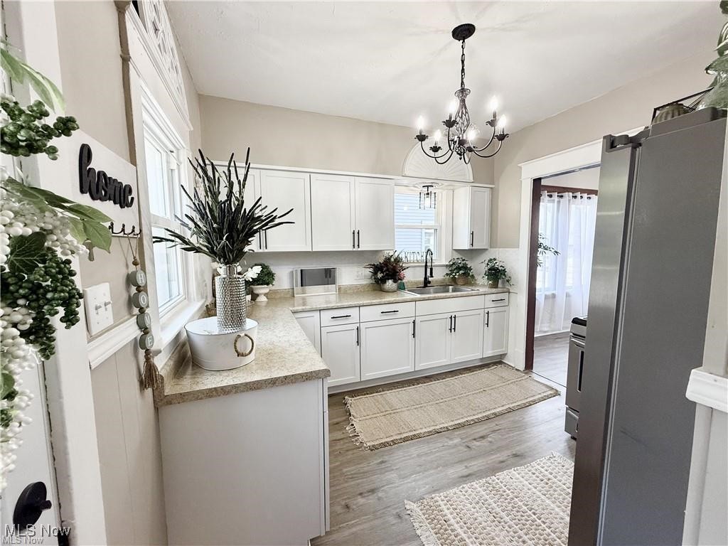281 Sexton Street Struthers, OH 44471 - Photo 12 of 28 Kitchen featuring appliances with stainless steel finishes, white cabinets, dark wood-type flooring, hanging light fixtures, and a chandelier